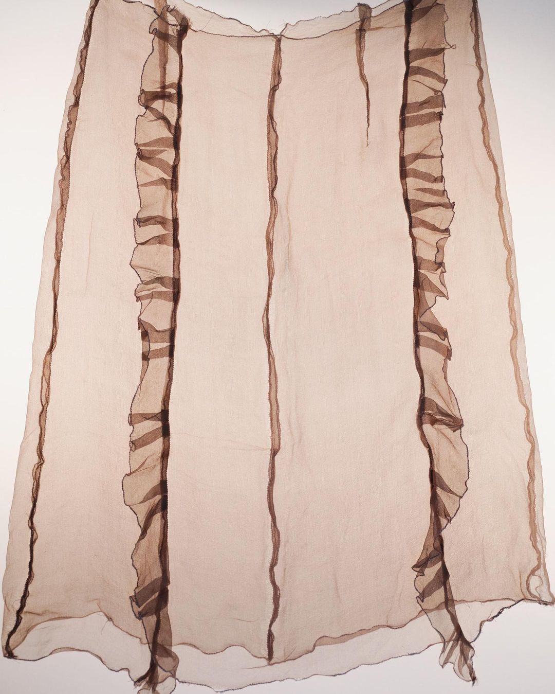 Light brown, sheer, ruffled fabric skirt with vertical stripes and ruffles for fashion design, apparel, or textile art projects.
