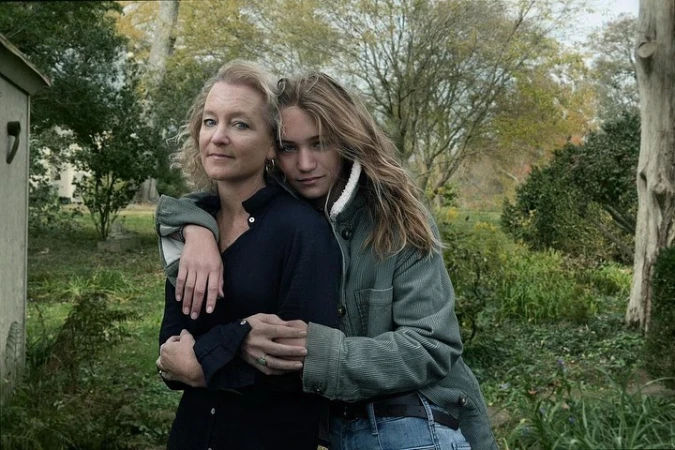 Portrait of two women embracing outdoors in a garden setting, photographed by Annie Leibovitz.