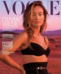 Olivia Wilde wearing a black bra top against a desert landscape sunset background for a Vogue magazine cover.
