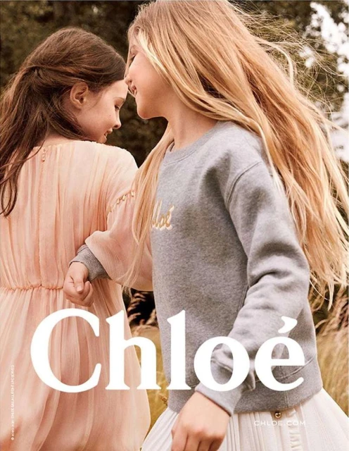Two young girls in Chloe clothing standing closely in an outdoor setting, fashion advertisement with visible Chloe logo and brand name.