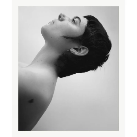 Black and white portrait of a woman with short dark hair in profile, tilted upward against a plain background.