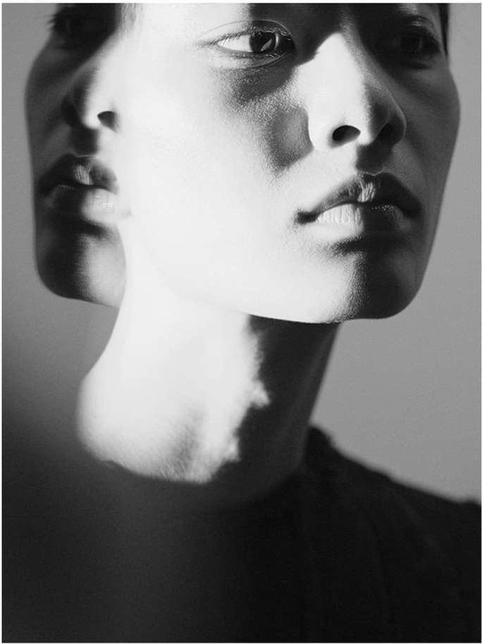 Monochromatic portrait of a person with layered facial features, shadows and highlights adding dimension and texture to the image.