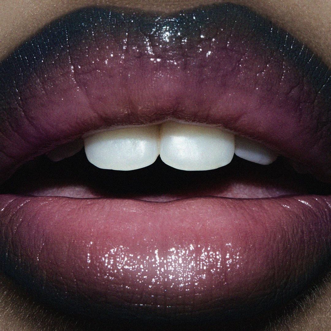 Close-up studio shot of a woman's lips with glossy gradient lipstick, showcasing makeup and beauty trends in a high-detail cosmetic fashion image.