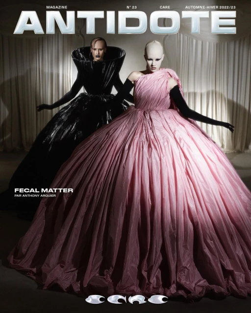 Magazine cover featuring two models in large gowns, one in pink and the other in black, against a neutral backdrop.