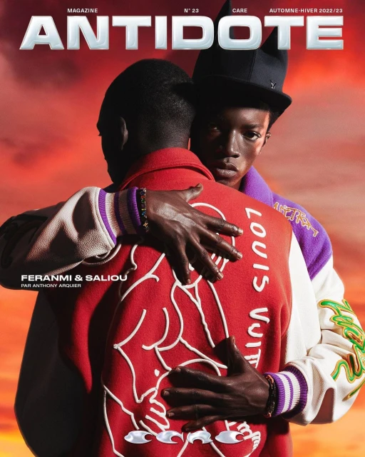 Magazine cover featuring two African American men in designer jackets; one looks at the camera, with red and orange blurred background.