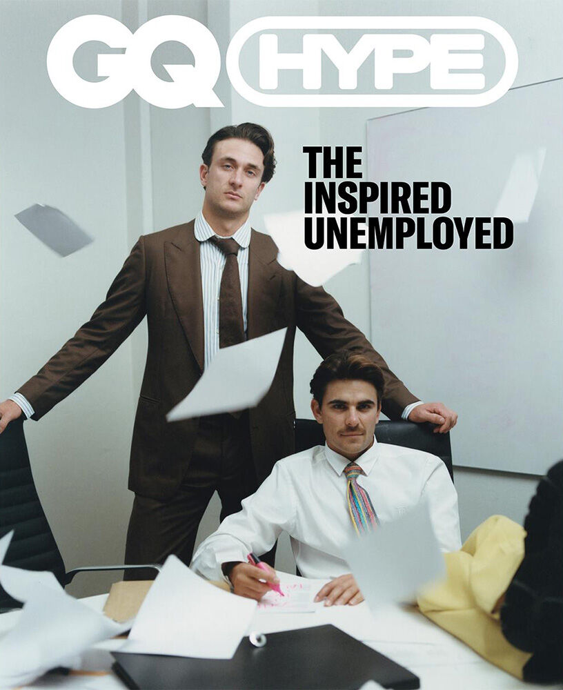 Magazine cover featuring two adult males in an office-style setting with paper strewn around; GQ Hype and 'The Inspired Unemployed' text.