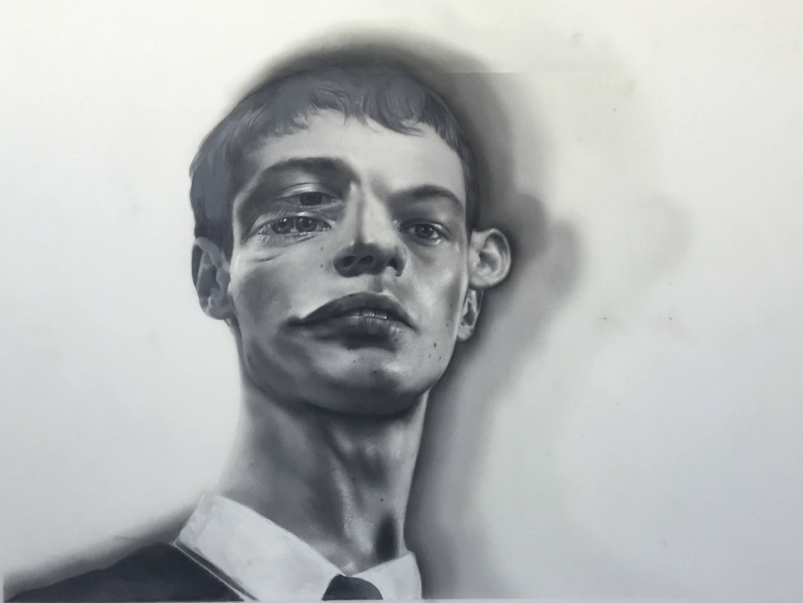 Monochrome painting portrait of a young adult with distorted features wearing a collared shirt, in a neutral indoor setting.