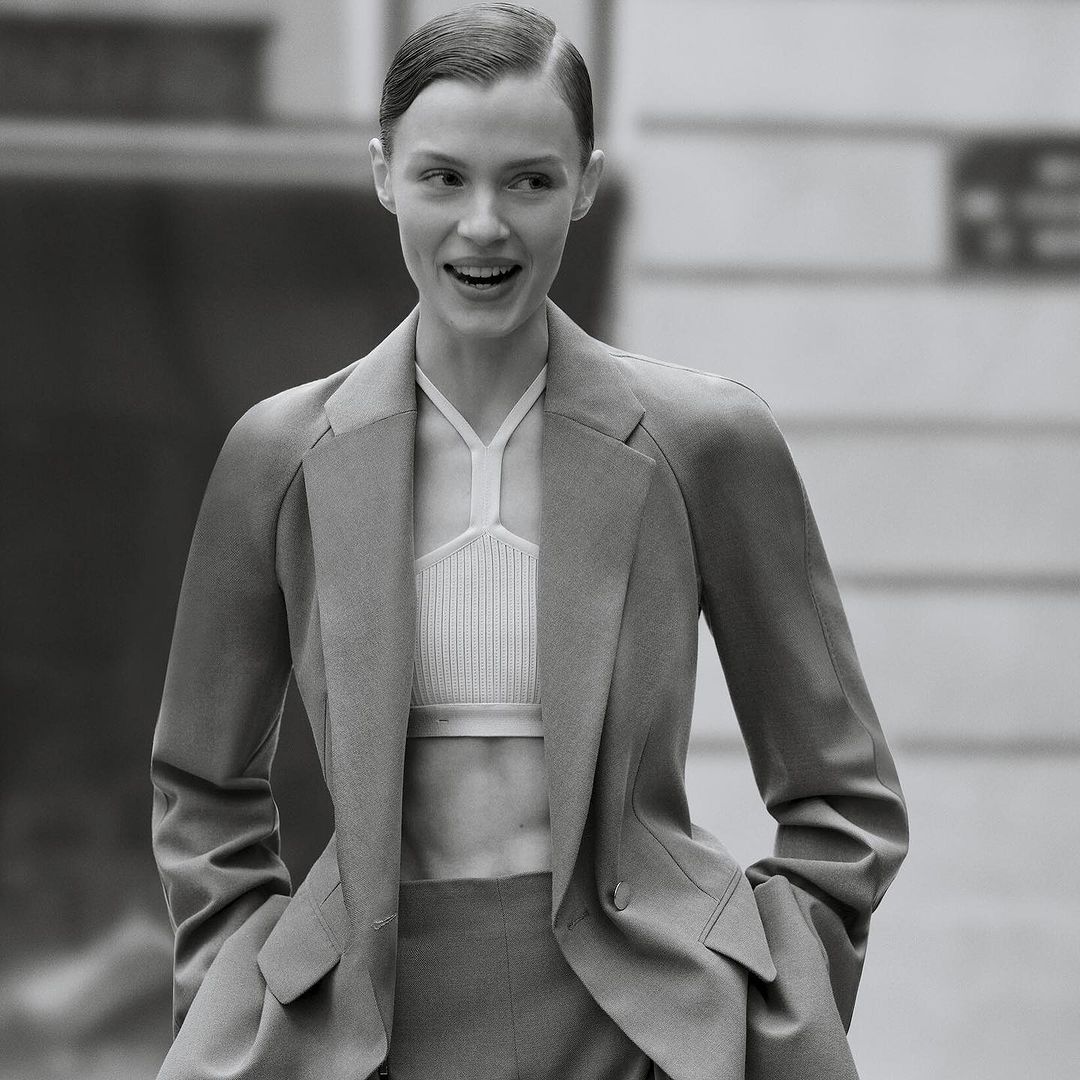 Monochrome portrait of a smiling woman wearing a tailored blazer and halter top photographed by Anthony Seklaoui
