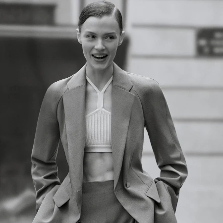 Monochrome portrait of a smiling woman wearing a tailored blazer and halter top photographed by Anthony Seklaoui