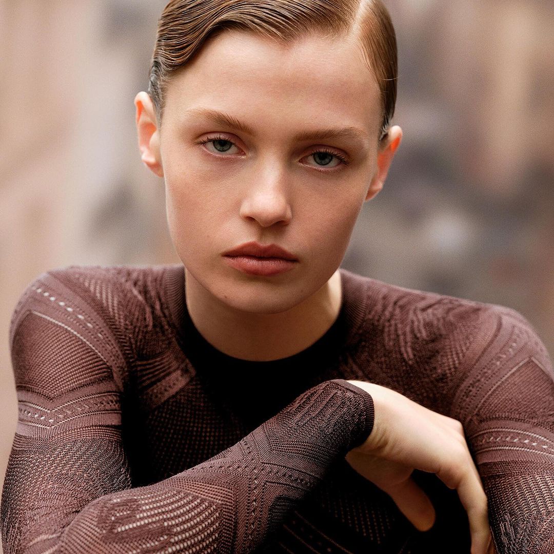 Close-up portrait of a woman with slicked-back hair wearing a patterned brown long-sleeve top by photographer Anthony Seklaoui.