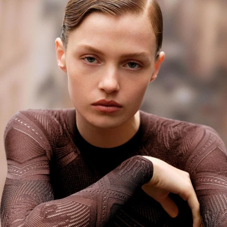 Close-up portrait of a woman with slicked-back hair wearing a patterned brown long-sleeve top by photographer Anthony Seklaoui.