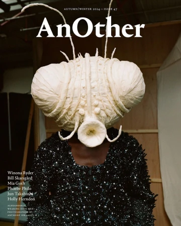 Magazine cover featuring a person wearing a large, elaborate, otherworldly headpiece and a black, sequined top against a studio backdrop.