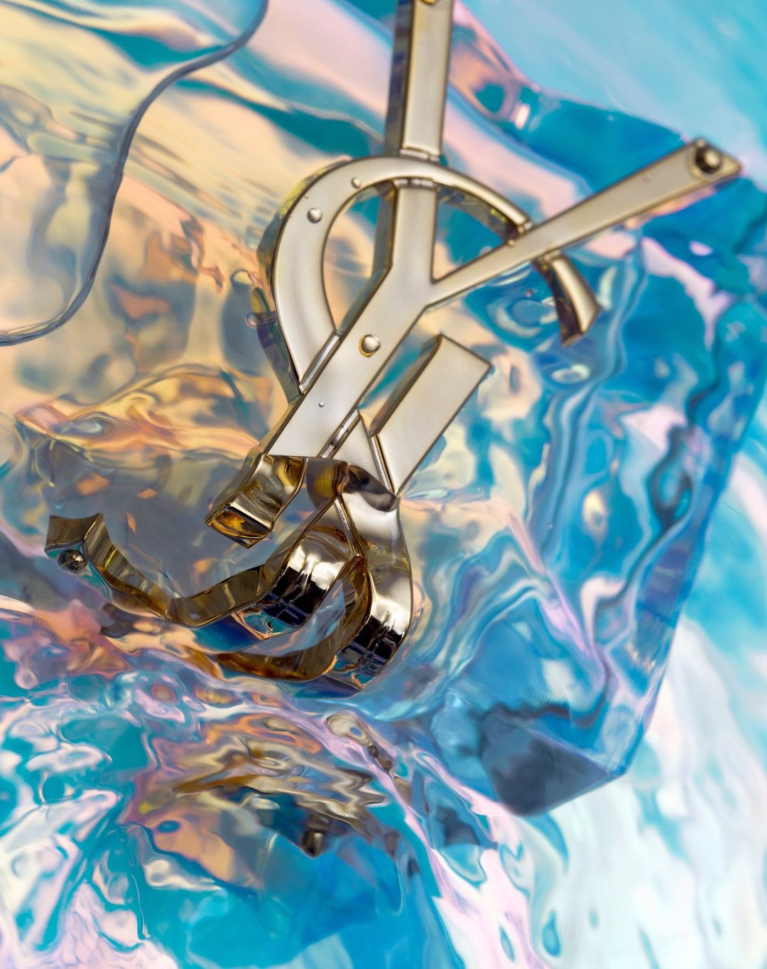 Close-up of a luxury designer logo in gold against an iridescent blue and gold fluid background, emphasizing brand recognition and high-end fashion.