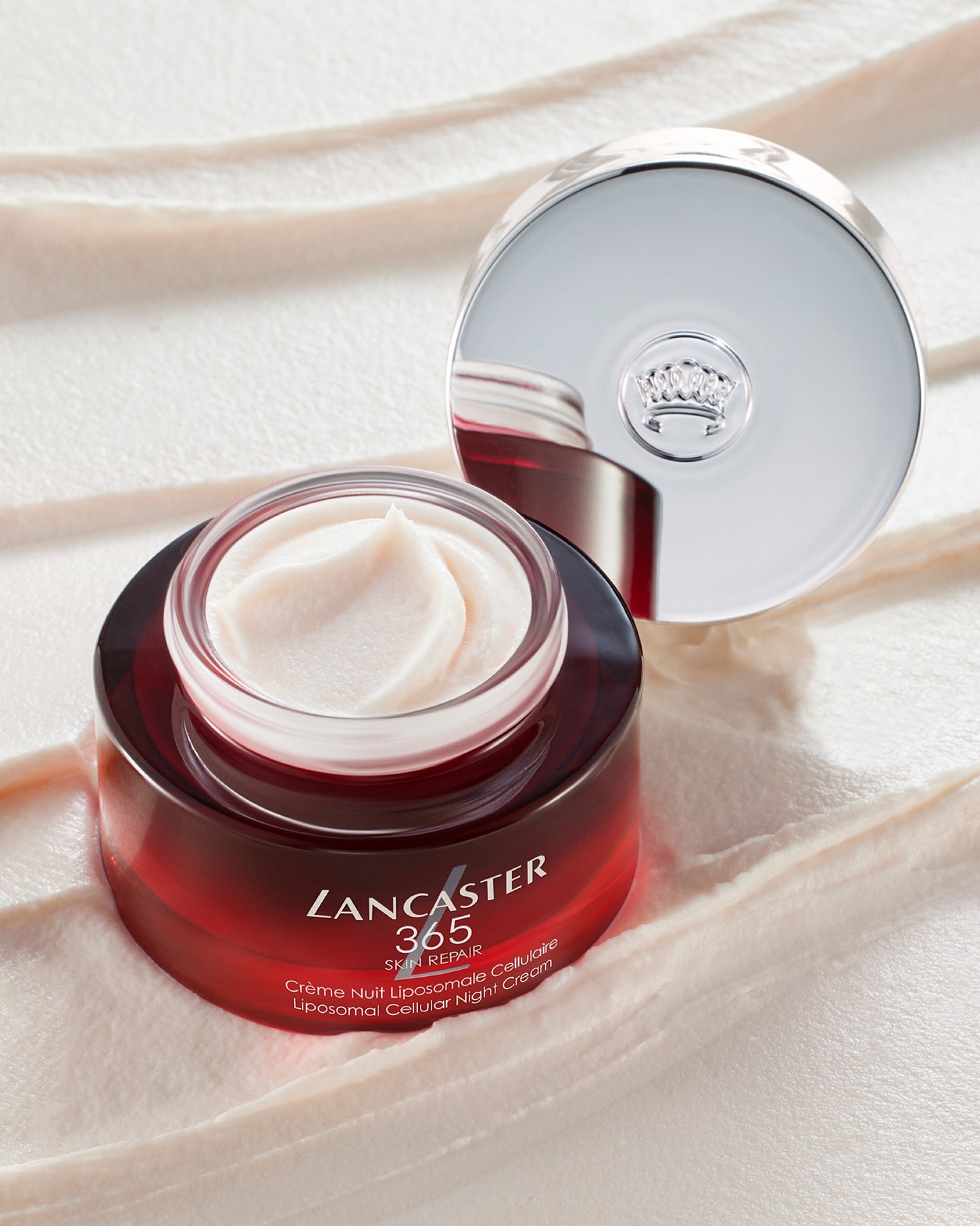 Lancaster 365 Skin Repair cream jar and lid on a satin background in a beauty shot, close-up of the skincare product.