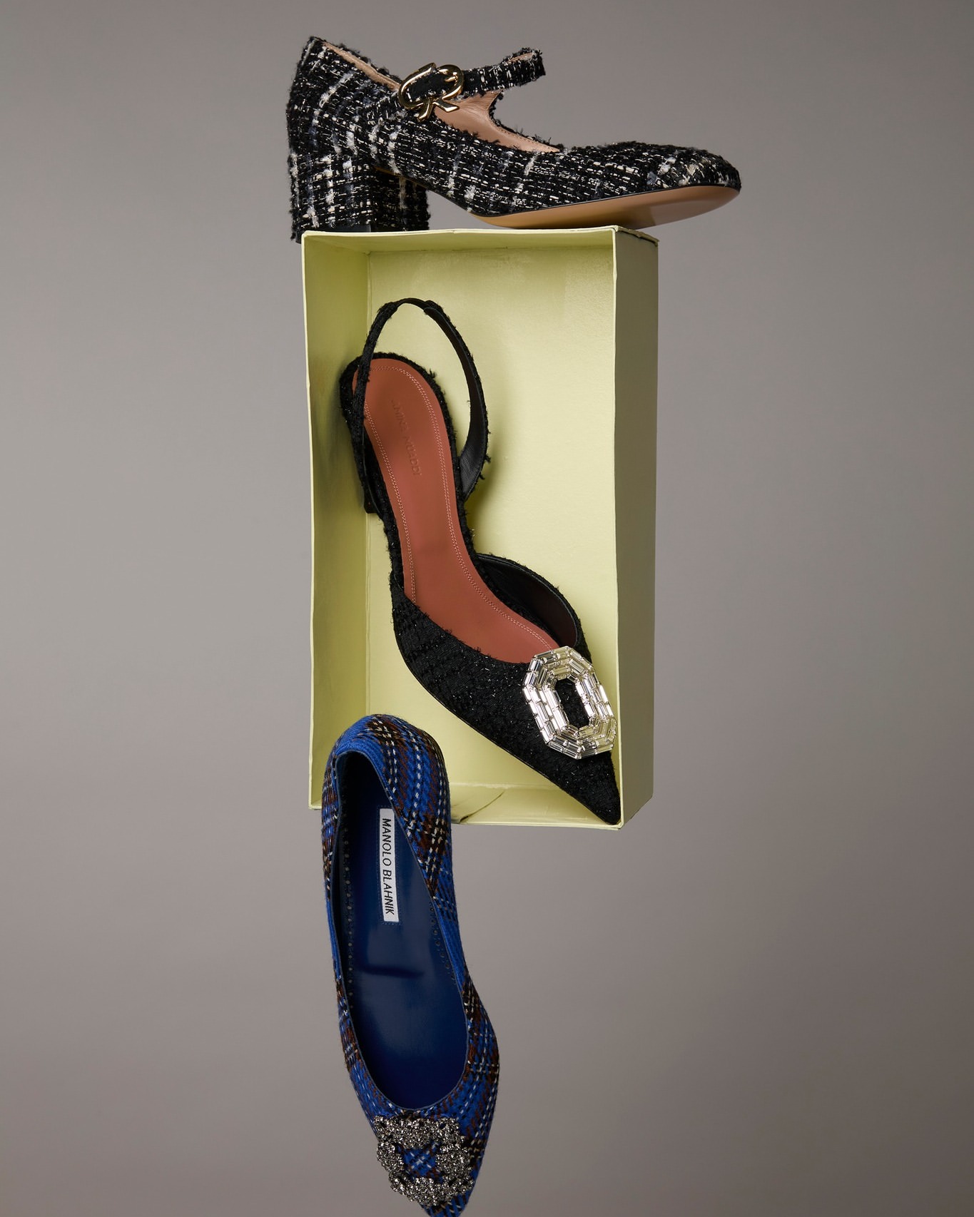 Three stylish women's shoes are arranged in a stack, including a pair of heeled Mary Janes and a slingback pump.