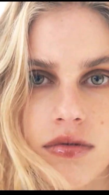 Close-up portrait of an adult female with blonde hair, wearing glossy lipstick, and looking directly at the camera, beauty shot.