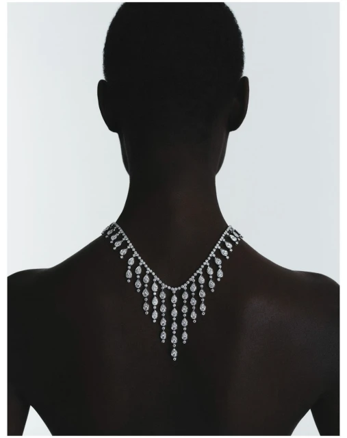 Elegant high jewelry diamond necklace showcased on a model's silhouette against a bright white background in a minimalist studio setting.