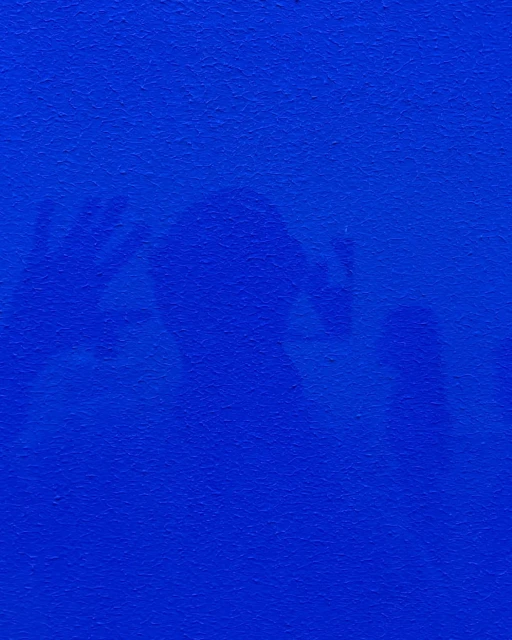 Abstract blue background with shadowy figures and hands, creating a mysterious and textural visual effect.