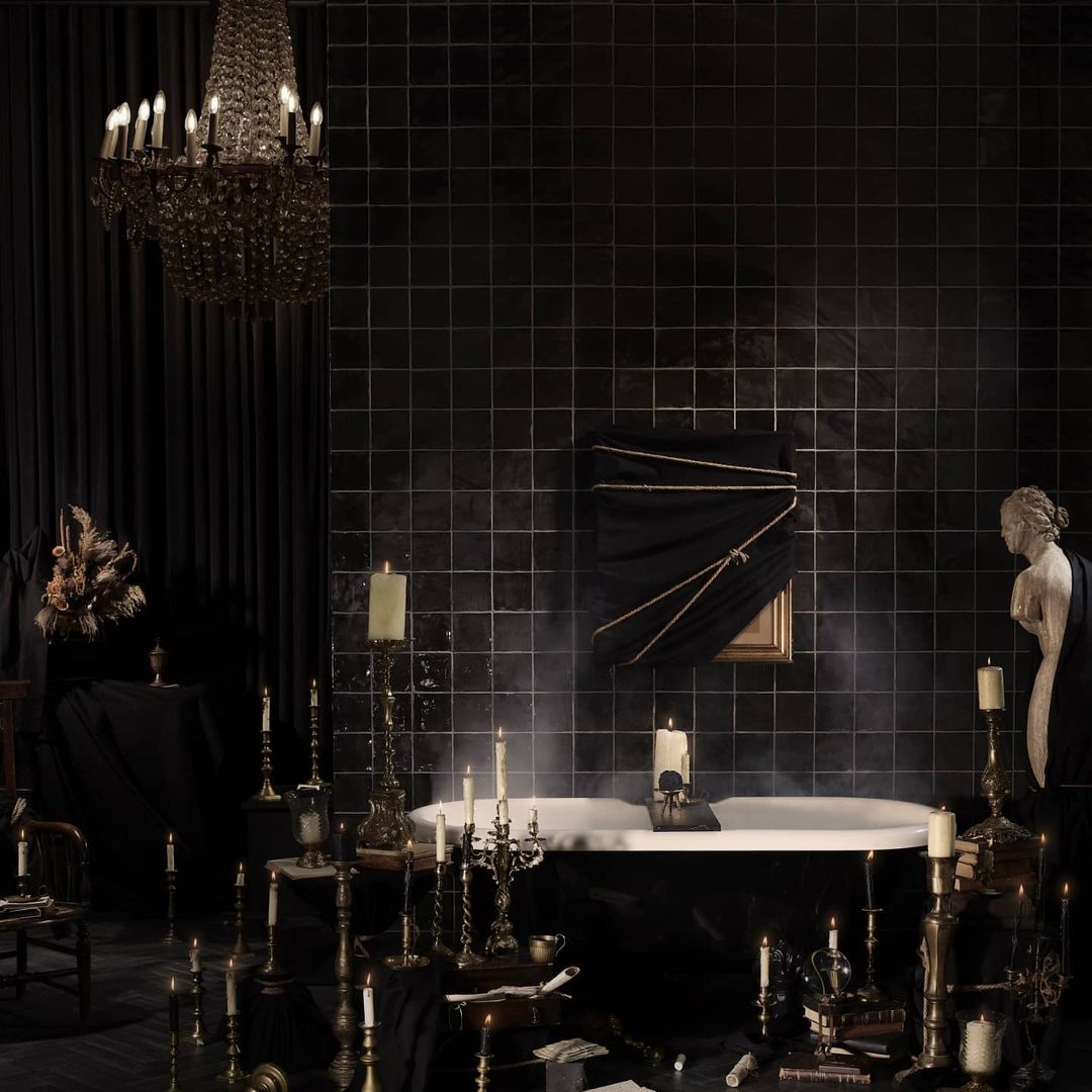 Dark bathroom scene with freestanding bathtub, candles, and chandelier creating a mysterious and elegant atmosphere, featuring vintage decor.
