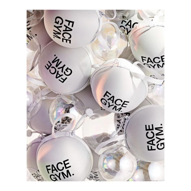 Close-up shot of multiple white and clear ornamental balls with black brand-name text. Spherical shapes, holiday concepts, decorative elements.