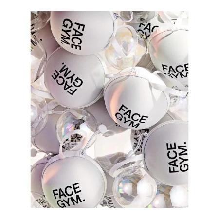 Close-up shot of multiple white and clear ornamental balls with black brand-name text. Spherical shapes, holiday concepts, decorative elements.