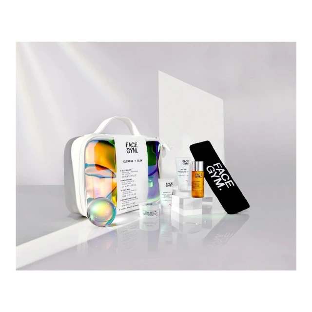 Face Gym skincare product set featuring a bag, orb, and skincare products in white packaging, displayed on a glossy white surface.