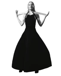 Model in a long black dress holding straps against a seamless white background, photographed by Anuschka Blommers & Niels Schumm