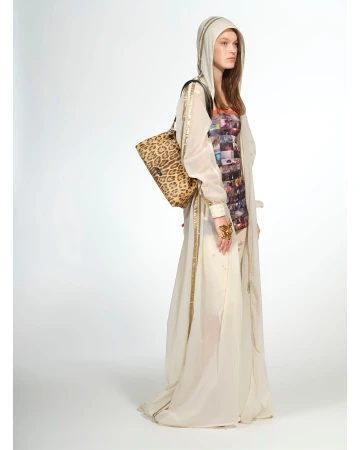 Model wearing a sheer hooded robe over a patterned dress holding a leopard print shoulder bag against a white background