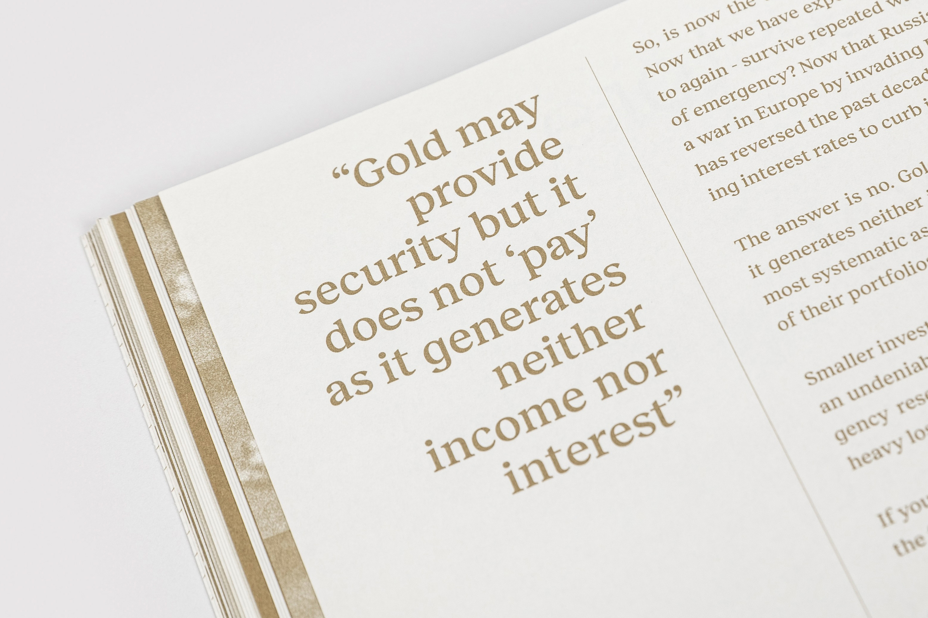 Close-up photograph of an open magazine page featuring editorial typography and a highlighted quote about gold in brown ink