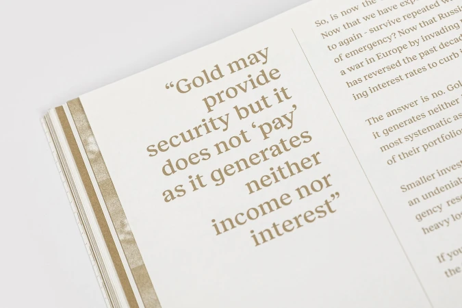 Close-up photograph of an open magazine page featuring editorial typography and a highlighted quote about gold in brown ink