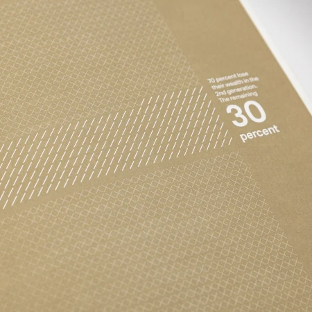 Close-up shot of brown textured paper with white typography and geometric pattern details by NAMENAME Creative Partners