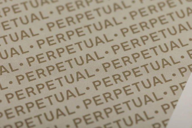 Detailed macro view of repeated typographic word perpetual printed in beige text across a textured neutral surface