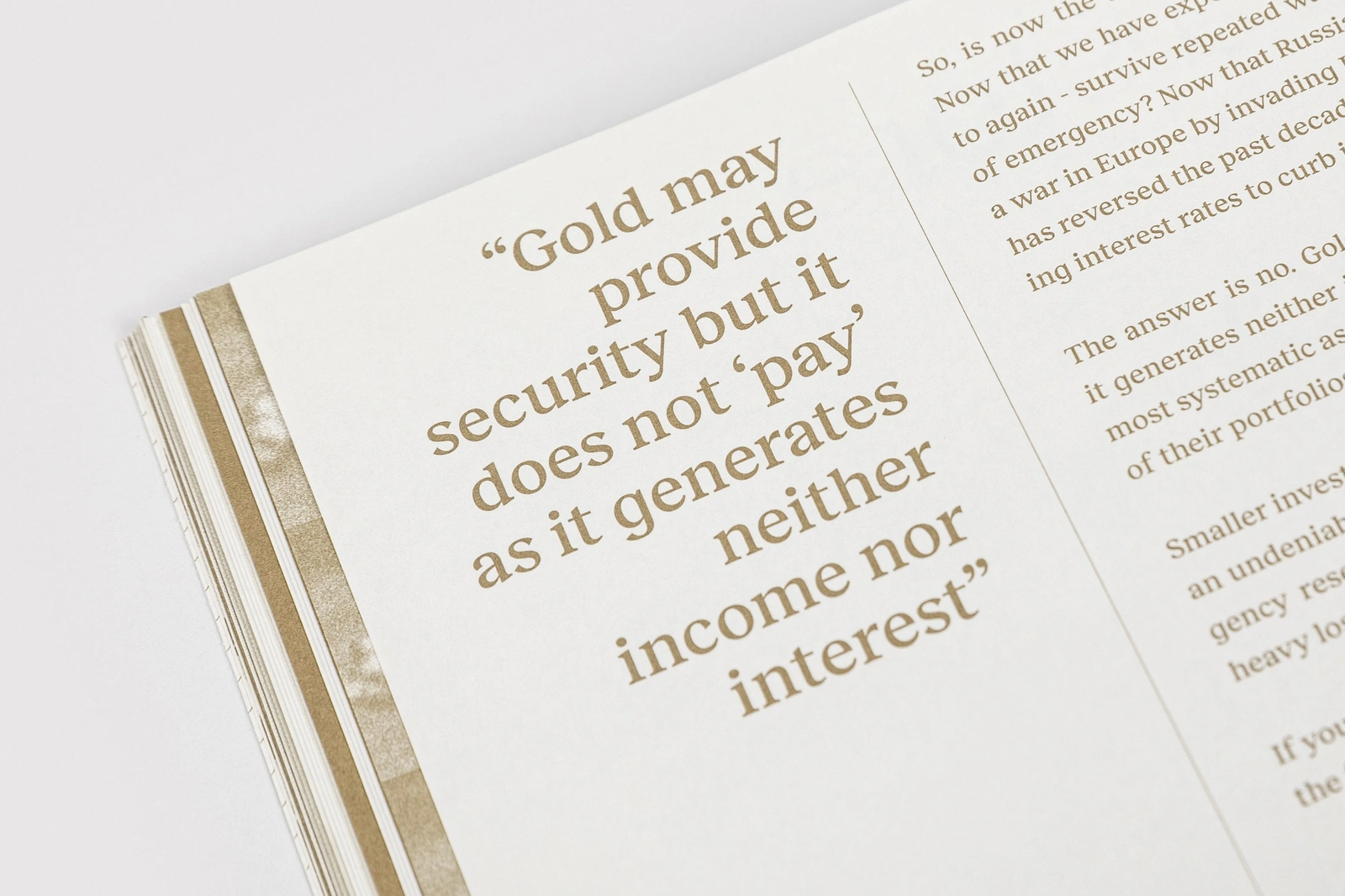 Close-up photograph of an open magazine page featuring editorial typography and a highlighted quote about gold in brown ink