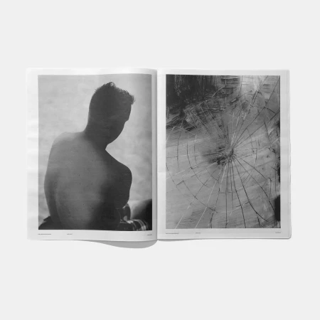 Two pages of a monochrome art magazine featuring a torso of a man on the left and abstract broken glass artwork on the right.