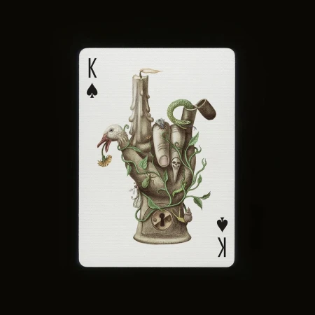 Intricate art playing card featuring a stone-like hand with a candle on top, adorned with foliage, a snake, a bird, and skulls.