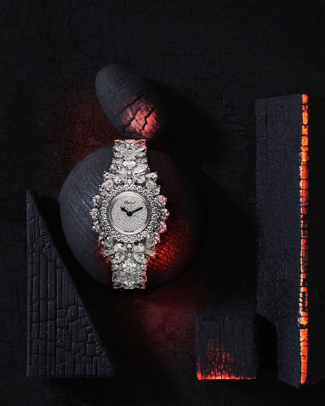 Elegant silver wristwatch with diamond embellishments, showcased against a contrasting dark backdrop with artistic wooden blocks.