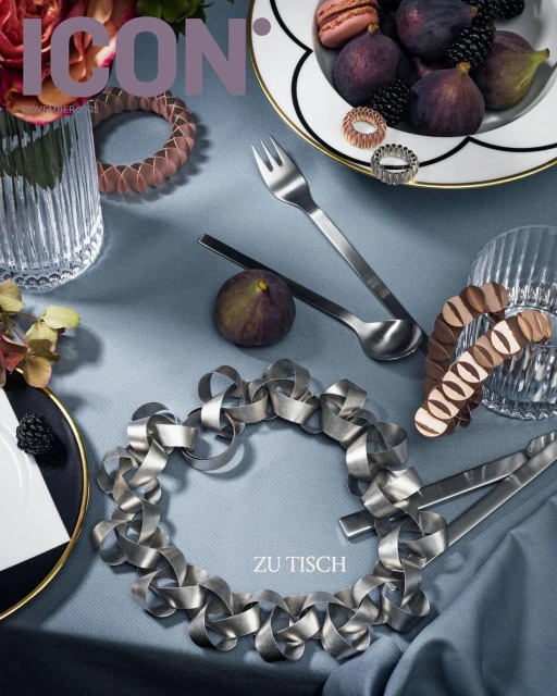 Still life of figs, blackberries, silverware, and table decorations on a light blue tablecloth, styled for an ICON magazine cover.