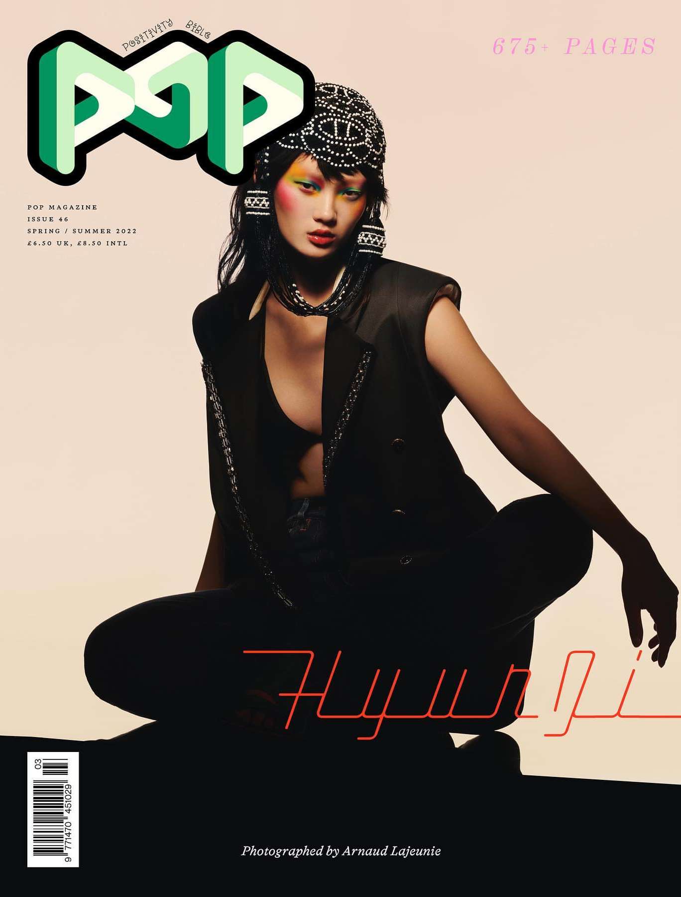 Magazine cover featuring an Asian model in a stylish black outfit and beaded headpiece, set against a soft gradient background.