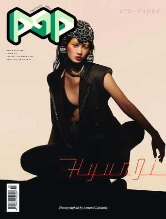 Magazine cover featuring an Asian model in a stylish black outfit and beaded headpiece, set against a soft gradient background.