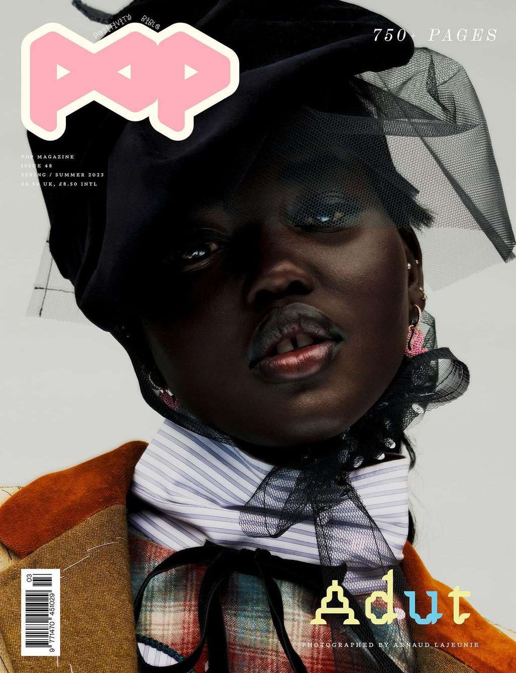 Magazine cover featuring a dark-skinned model in a hat and striped top, styled with a plaid jacket and visible 'POP' logo.