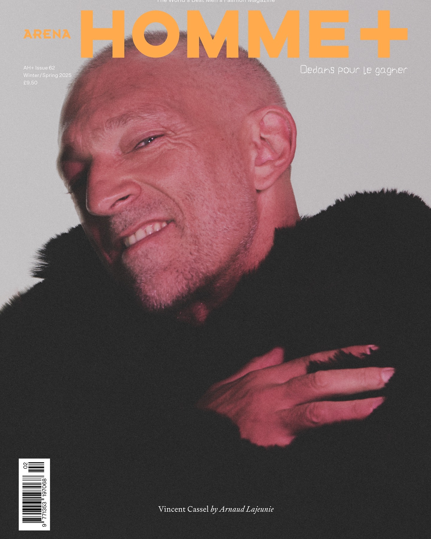 Arena Homme+ magazine cover featuring a close-up of a smiling adult male with short hair and a dark textured jacket against a light background.
