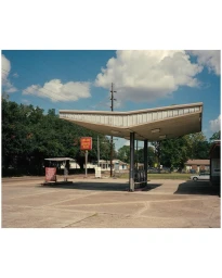 Vintage service station canopy in Paris photographed under a blue sky with fluffy white clouds by Arnaud Montagard.
