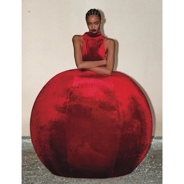Elegant fashion shot featuring an adult female in a red velvet dress with a full, spherical skirt, posing in a studio setting. 