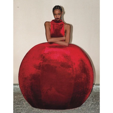 Elegant fashion shot featuring an adult female in a red velvet dress with a full, spherical skirt, posing in a studio setting. 