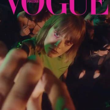 Vogue Russia magazine cover featuring a young adult woman looking at the camera with hands raised in a nightclub setting.