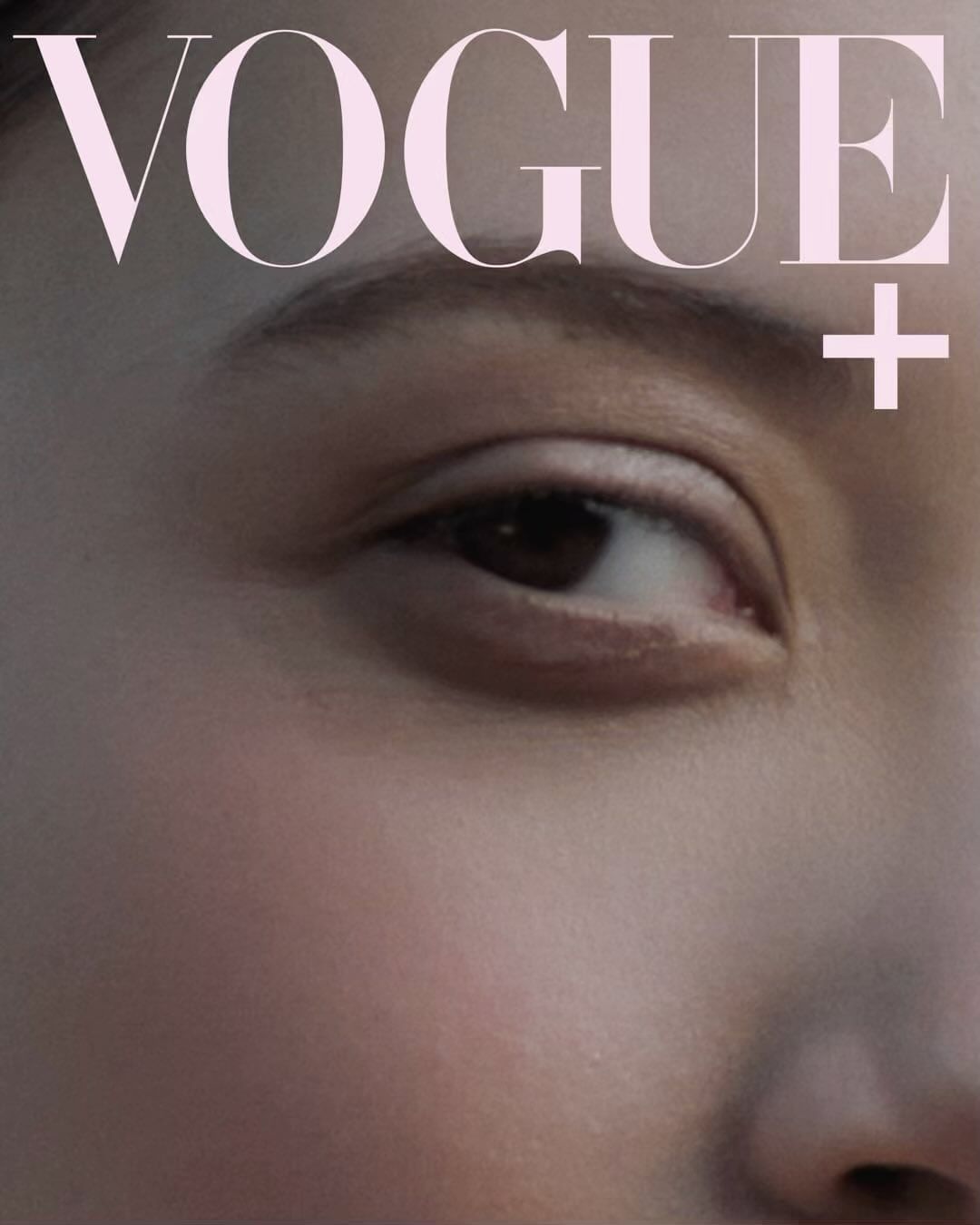 Close-up of a fashion magazine cover featuring a fair-skinned person's eye, part of their face, and the pink masthead VOGUE.