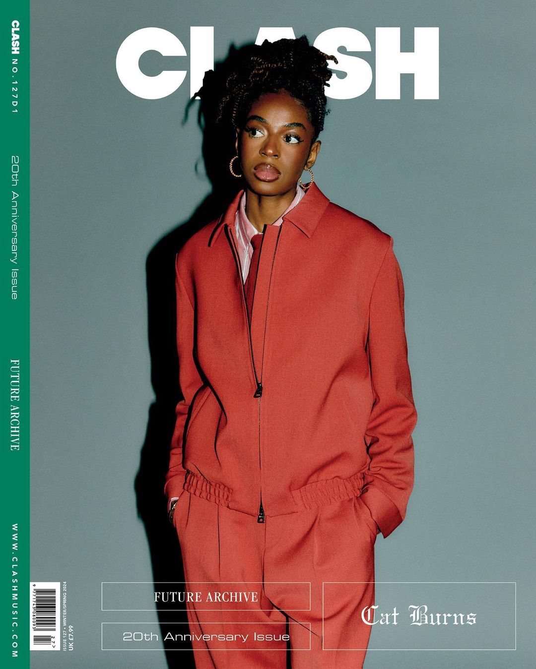 Magazine cover featuring a stylish young Black woman in a red suit, photographed in portrait orientation against a solid grey background.