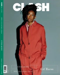 Black woman wearing a red jacket and matching pants standing against a solid grey background