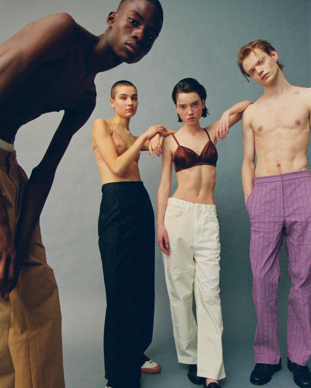 Four fashion models in a studio pose, wearing casual separates in a fashion editorial layout, neutral background with natural lighting.