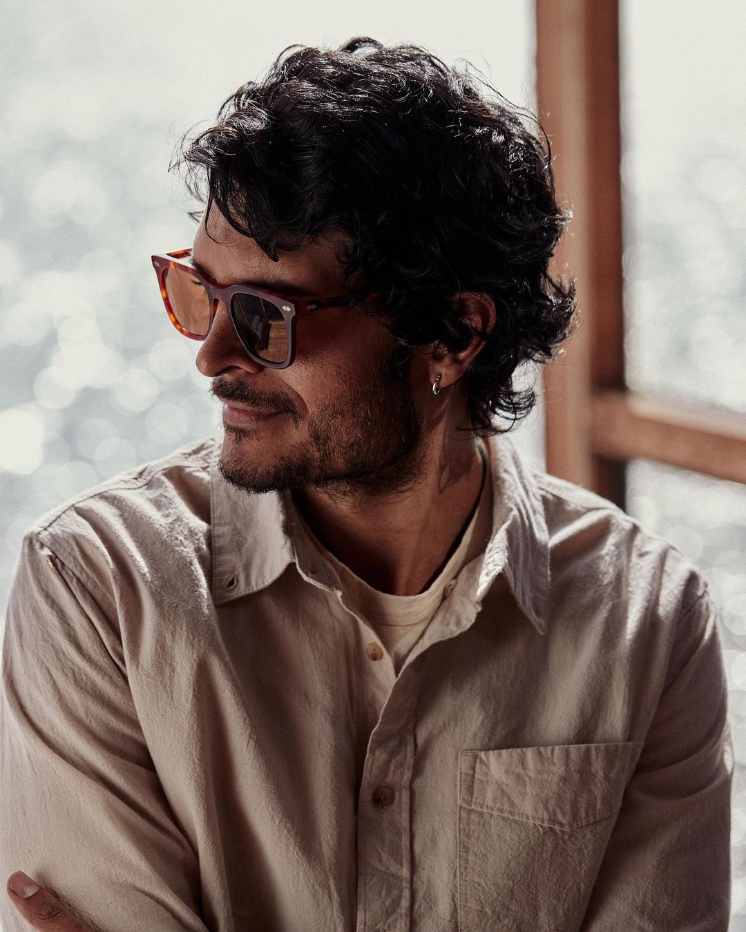 Man wearing tortoiseshell sunglasses and a light button-down shirt photographed by Arturo Torres in New York.